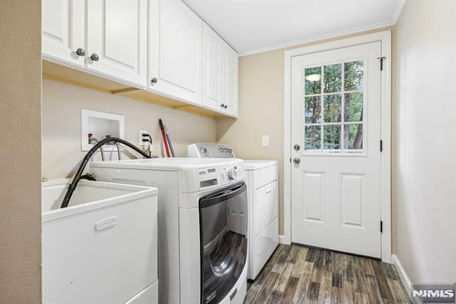 laundry area with dark wood-type flooring, cabinets, washing machine and clothes dryer, and sink