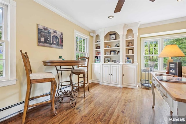 dining space featuring ceiling fan, light wood-type flooring, built in shelves, and ornamental molding