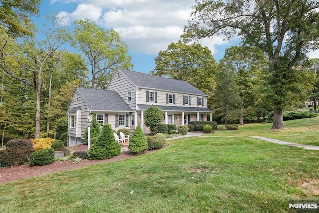 colonial-style house featuring a front yard