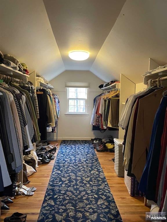 walk in closet featuring vaulted ceiling and hardwood / wood-style flooring