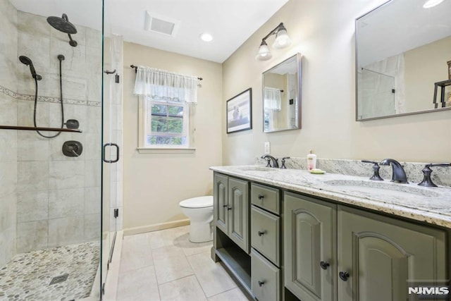 bathroom featuring toilet, a shower with door, tile patterned floors, and vanity