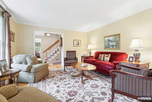 living room with light wood-type flooring and crown molding