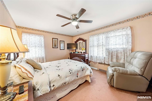 carpeted bedroom with ceiling fan and radiator heating unit