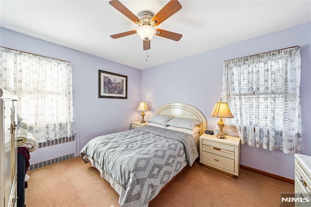 carpeted bedroom featuring ceiling fan and radiator