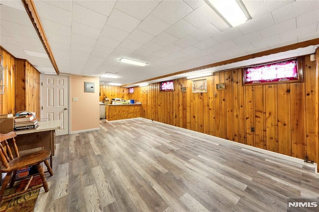 basement featuring wood-type flooring and wooden walls