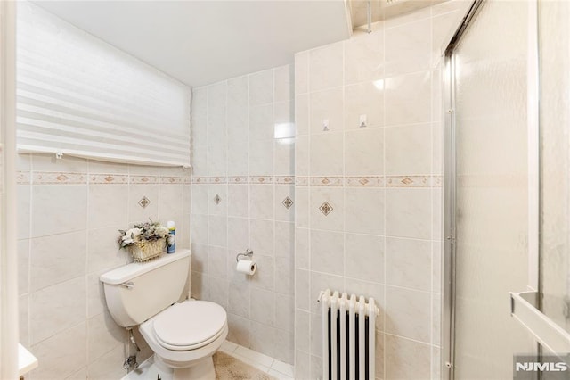 bathroom with toilet, radiator, tile walls, and tile patterned floors