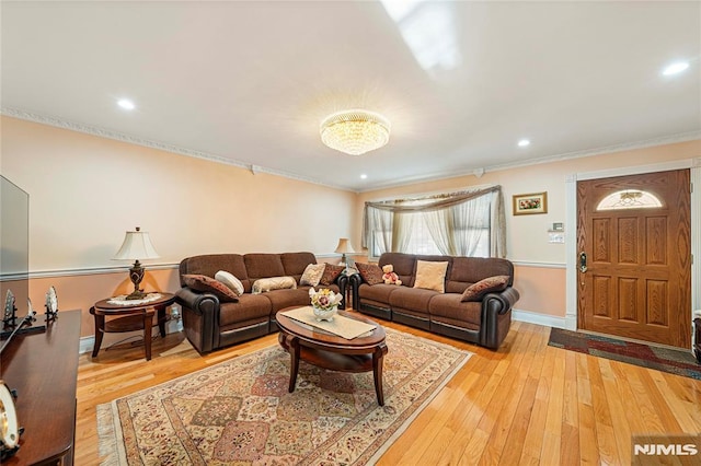 living room featuring ornamental molding and light hardwood / wood-style floors