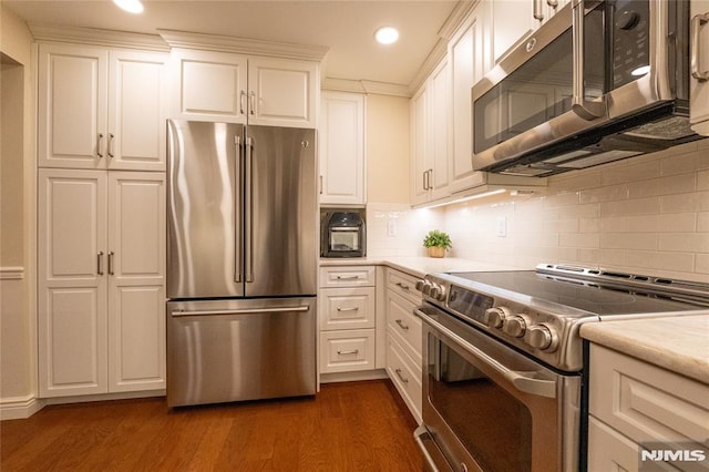 kitchen with dark hardwood / wood-style floors, appliances with stainless steel finishes, backsplash, and white cabinetry