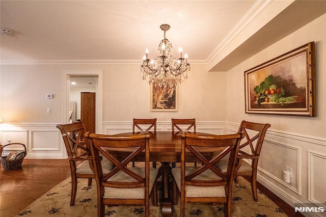 dining space with dark wood-type flooring, a chandelier, and crown molding