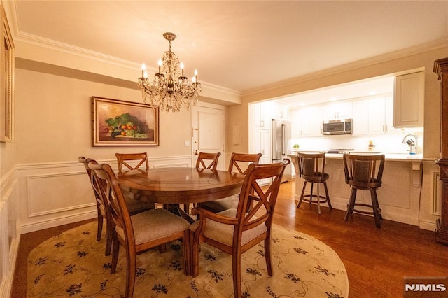 dining space with an inviting chandelier, dark hardwood / wood-style flooring, sink, and crown molding