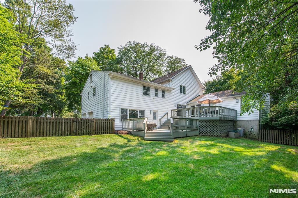 back of house featuring a yard and a deck