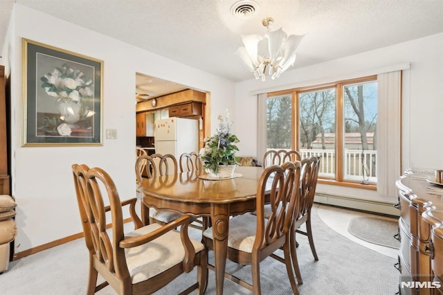 dining space with a notable chandelier, baseboard heating, and light carpet