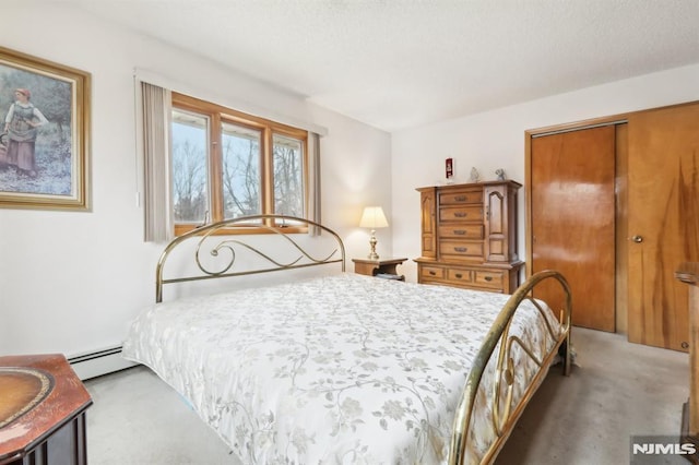 bedroom with a closet, a baseboard radiator, and carpet flooring