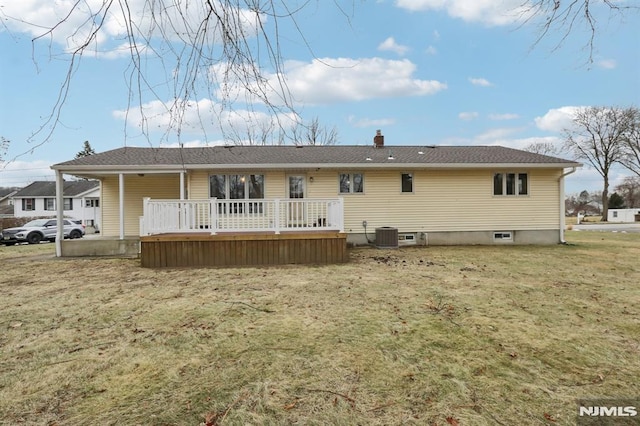 rear view of property with a deck and a yard