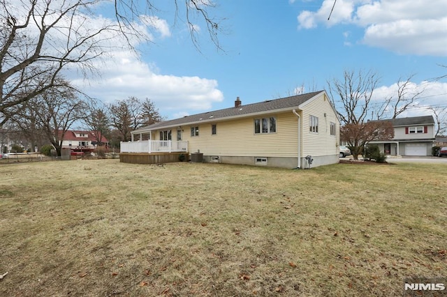 back of property with a lawn and a deck