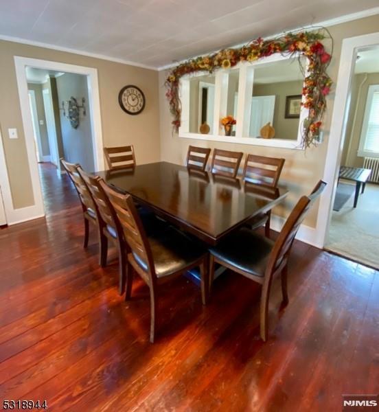 dining area with hardwood / wood-style flooring and crown molding