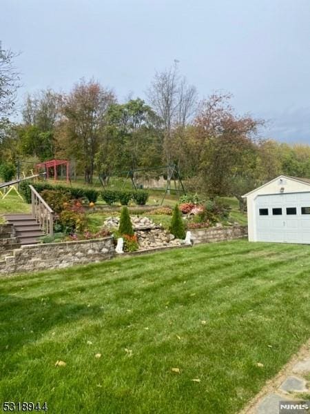 view of yard with a garage and an outbuilding