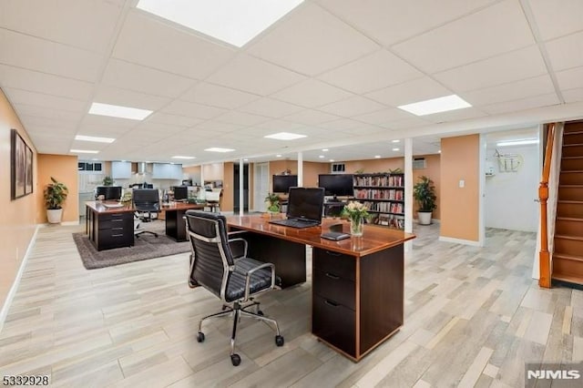 home office featuring a paneled ceiling and light wood-type flooring