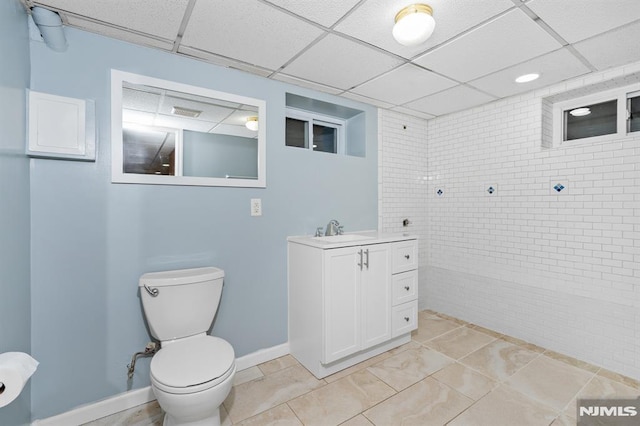 bathroom with toilet, tile patterned floors, a paneled ceiling, and vanity