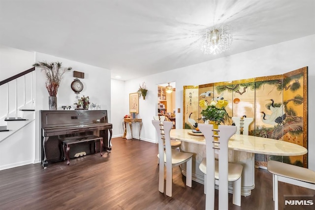 dining room featuring ceiling fan with notable chandelier and dark hardwood / wood-style flooring