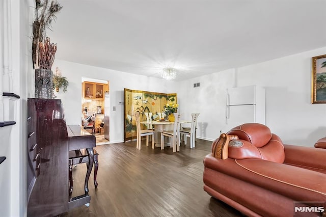 living room featuring a chandelier and dark hardwood / wood-style floors