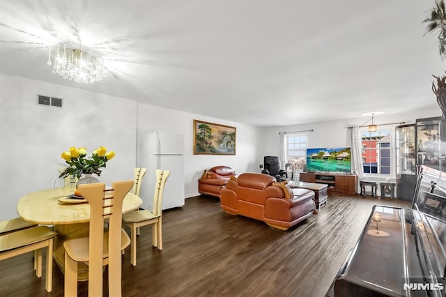 living room featuring dark hardwood / wood-style flooring and an inviting chandelier