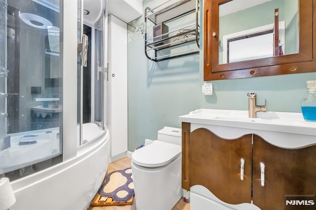 full bathroom featuring toilet, wood-type flooring, vanity, and shower / bath combination with glass door