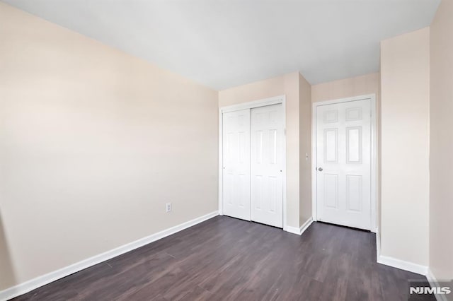 unfurnished bedroom featuring dark wood-type flooring and a closet