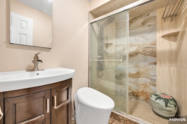 bathroom featuring toilet, a shower with door, and vanity