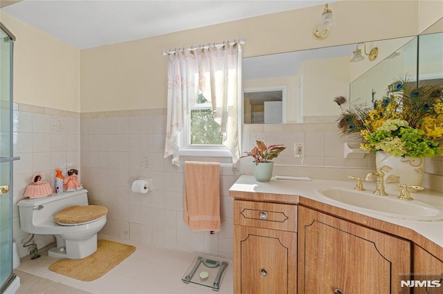 bathroom featuring toilet, tile patterned flooring, tile walls, and vanity