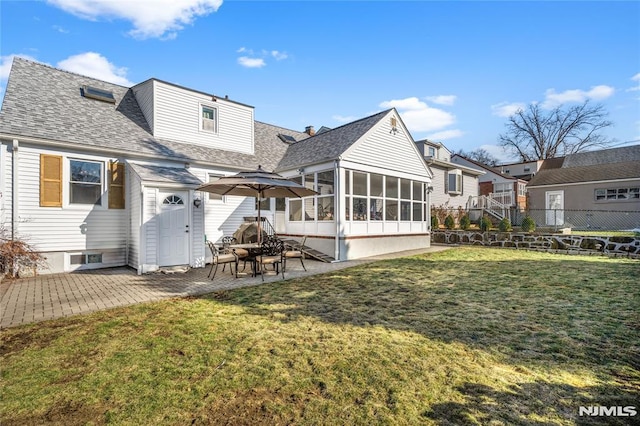 rear view of property with a patio area, a lawn, and a sunroom