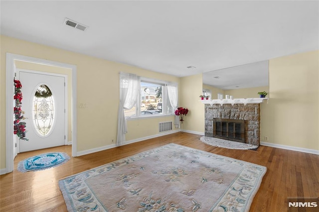 living room with a fireplace and wood-type flooring