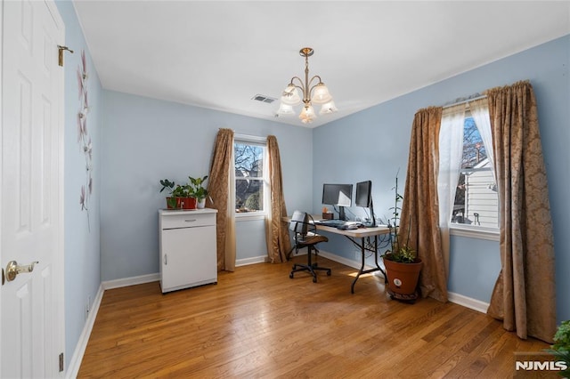 office space with light hardwood / wood-style flooring and a chandelier