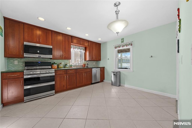 kitchen featuring light tile patterned floors, tasteful backsplash, plenty of natural light, and appliances with stainless steel finishes