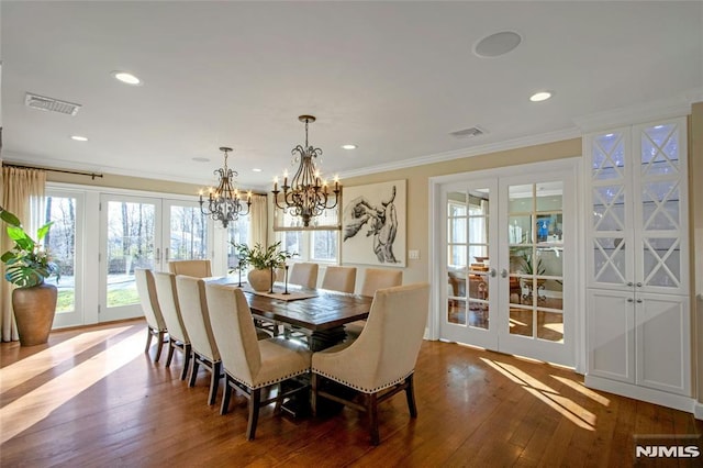 dining room featuring french doors, dark hardwood / wood-style flooring, a notable chandelier, and crown molding