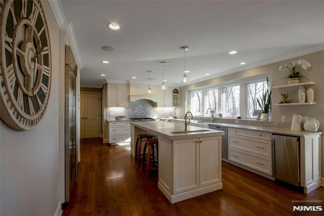 kitchen with an island with sink, dark hardwood / wood-style flooring, fridge, stainless steel dishwasher, and decorative light fixtures