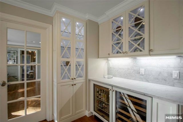 bar with tasteful backsplash, beverage cooler, crown molding, and light stone countertops