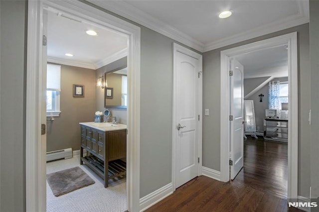 hall with ornamental molding, dark wood-type flooring, a baseboard radiator, and sink