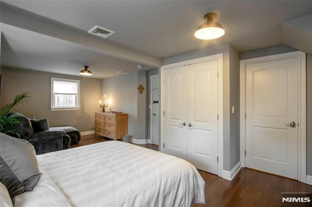 bedroom with dark hardwood / wood-style flooring and a closet