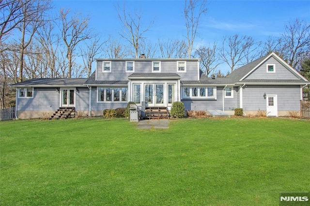 rear view of property with a lawn