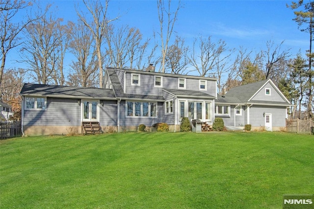 rear view of house featuring a yard