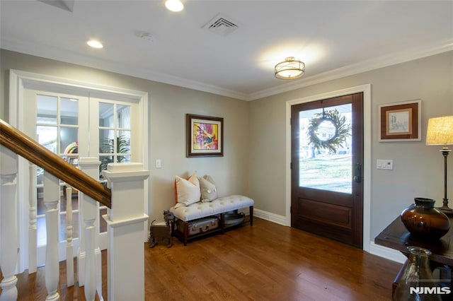 foyer entrance with ornamental molding and dark hardwood / wood-style flooring