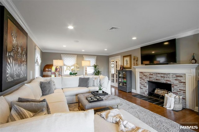 living room featuring a brick fireplace, crown molding, and dark hardwood / wood-style floors