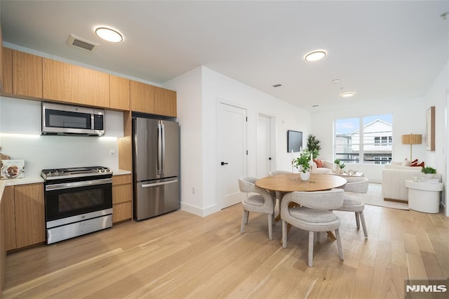 kitchen with stainless steel appliances and light hardwood / wood-style floors