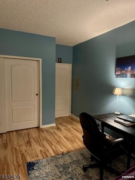 office area featuring a textured ceiling and light wood-type flooring