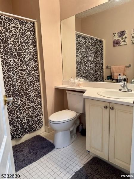 bathroom with tile patterned flooring, vanity, and toilet