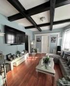 living room featuring beamed ceiling and hardwood / wood-style flooring