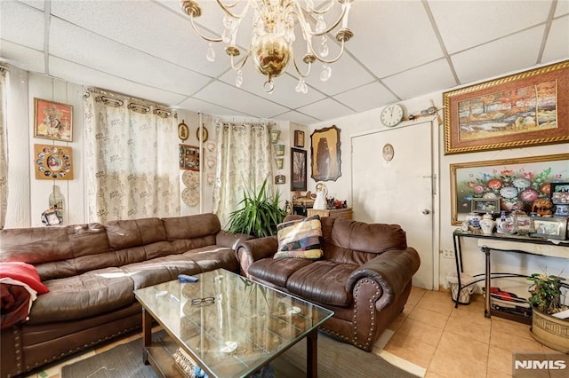 tiled living room featuring a paneled ceiling and an inviting chandelier