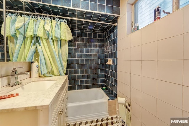 bathroom with tile walls, vanity, and shower / bath combo