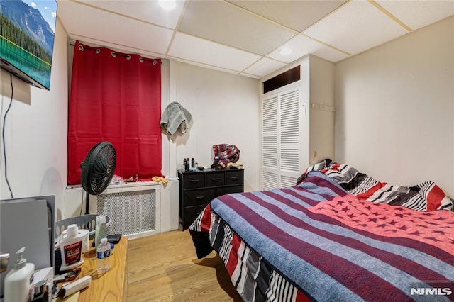 bedroom with hardwood / wood-style flooring and a paneled ceiling